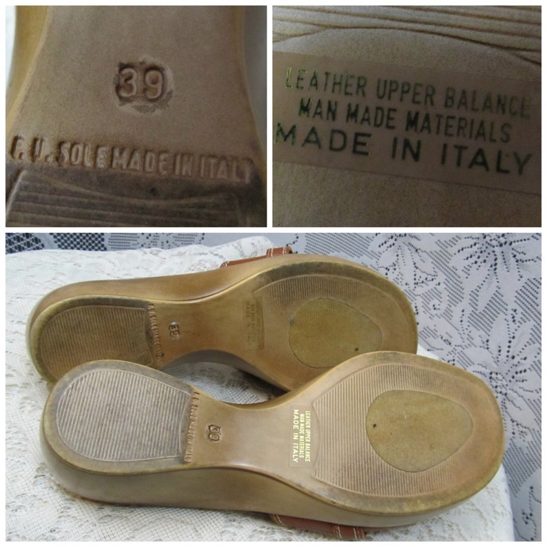 May include: A pair of brown leather wedge sandals with a brown leather strap. The sandals have a size 39 label on the sole and say "Leather Upper Balance Man Made Materials Made in Italy" on the insole.
