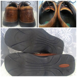 May include: A pair of brown leather shoes with black soles. The shoes have a lace-up closure and a logo on the side. The shoes are shown from the top and the bottom.