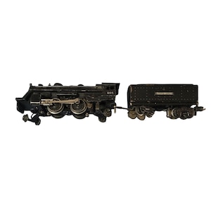 May include: A vintage black toy train set, comprising a locomotive and a separate carriage. The locomotive features visible wheels and mechanical details. The carriage is labelled "SOUTHERN LINES". The train is set against a white background.