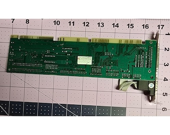 Puede incluir: Una placa de circuito verde con un conector negro y un cable de cinta. La placa tiene una etiqueta que dice "Award Winning 2.0 Sound Blaster Pro 16 bit Stereo Sound Card".