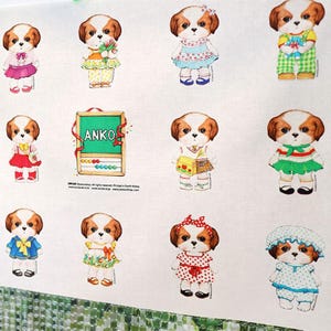 Pode incluir: Um tecido branco com um padr&atilde;o repetido de c&atilde;es de desenho animado vestindo roupas diferentes. Os c&atilde;es est&atilde;o todos vestindo vestidos, camisas e cal&ccedil;as. H&aacute; um quadro-negro com a palavra "ANKO" escrita nele.