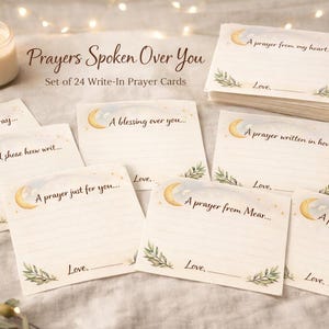 May include: A set of 24 write-in prayer cards with a crescent moon and botanical design. The cards have lines for writing and the phrases "Tonight I pray...", "A blessing over you...", and "A prayer from my heart..." are visible. A lit candle and a gold pen are also present.