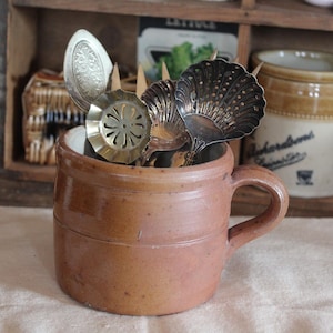 May include: A set of three ceramic mugs with a speckled, matte finish. The mugs are in shades of cream, light gray, and dark gray. Each mug has a simple, minimalist design, perfect for coffee or tea.