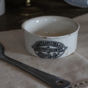 Może przedstawiać: Biała ceramiczna miska z czarnym napisem "J.W. Plumtree Ltd. Manufacturer of Home Potted Meats Railway St. Southport."