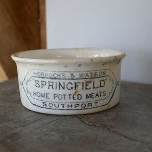 Puede incluir: Tarro de cerámica blanco con letras negras que dicen "Horrocks & Watson "Springfield" Home Potted Meats Southport".