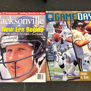 May include: Two vintage Jacksonville Jaguars football magazines. One cover features a player in a helmet with the text "A New Era Begins." The other magazine cover shows two players with the text "Game Day."