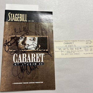 May include: A Stagebill from June 2000 for the play "Cabaret" at Studio 54, with signatures. The cover features a close-up of a person's face. A ticket for the play is also visible.