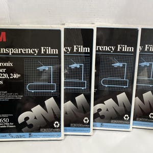 May include: Four packs of 3M Transparency Film for Tektronix Phaser 200, 220, and 240 series thermal transfer printers. Each pack has 50 sheets. The packaging is black with white and blue text and graphics.