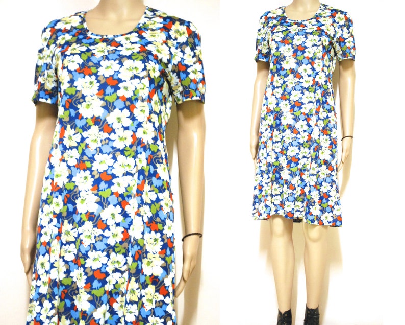 May include: A short-sleeved dress with a blue background and a white, red and green floral pattern.