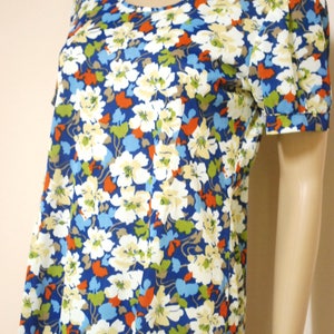 May include: A blue and white floral print short-sleeved dress with a scoop neck.