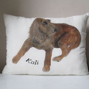 May include: A white pillow with a hand-painted illustration of a brown dog. The dog is looking to the left and the name "Kali" is written in black below the dog.