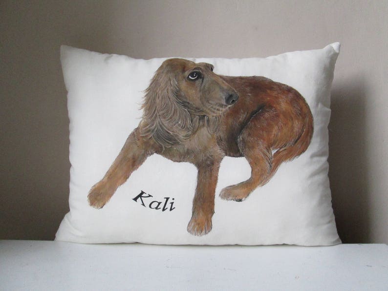 May include: A white pillow with a hand-painted illustration of a brown dog. The dog is looking to the left and the name "Kali" is written in black below the dog.