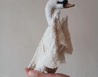 Arte têxtil com boneca cisne de conto de fadas, renda romântica e coroa dourada para decoração de quarto infantil ou berçário.