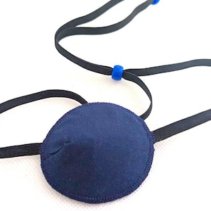 May include: A dark blue eye patch with a black elastic strap and blue adjustable toggles.