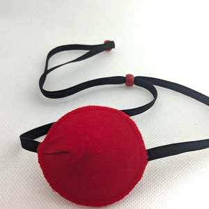 May include: Red eye patch with black elastic strap and red adjustable toggles.