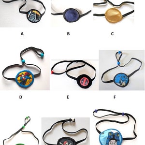 May include: Nine different eye patches with various designs, including a Superman, a Deadpool, a pirate skull, and a Thomas the Tank Engine. The eye patches are all black with a colourful design on the front. They are all attached to a black elastic strap with a blue bead on one end.