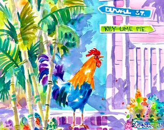 May include: A watercolor painting of a rooster standing on a brick path in front of a pink building with a sign that reads "Mallory Square, Duval St., Key Lime Pie". The rooster is blue, orange, and purple. The painting is signed "Ellen Negley".