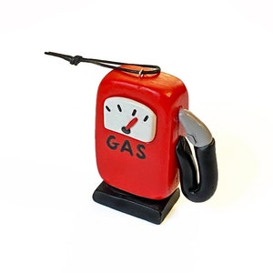 May include: Red and black gas pump ornament with a gauge that reads "GAS".