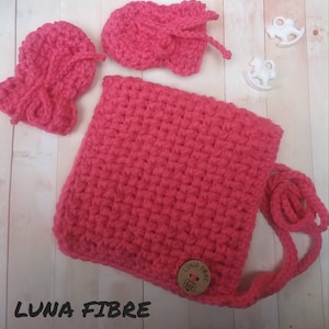 May include: A pink crocheted baby bag with a long strap and a small wooden button with the text "LUNA FIBRE".