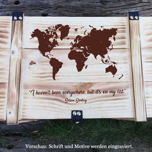Può includere: Una scatola di legno con un design a mappa del mondo e la citazione "Non sono stato ovunque, ma è sulla mia lista." di Susan Sontag. La scatola è realizzata in legno chiaro con una macchia marrone e ha accenti metallici.