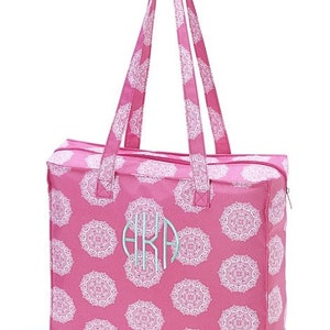 Puede incluir: Una bolsa de mano rosa con dise&ntilde;os de mandalas blancas y un monograma "AKA" en azul claro. La bolsa tiene dos asas superiores y un cierre de cremallera.