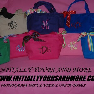 May include: A collection of eight personalized insulated lunch totes in various colors, including green, pink, blue, and beige. Each tote features a different embroidered monogram, such as "CM", "Debbie", "TDH", "Kosli", and "Tammy". The totes are displayed on a pink surface with the text "INITIALLY YOURS AND MORE WWW.INITIALLYYOURSANDMORE.COM MONOGRAM INSULATED LUNCH TOTES".