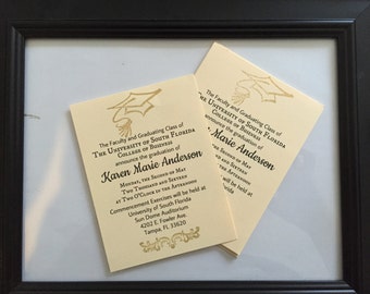 May include: Two cream-colored graduation announcements with gold accents and black text are displayed in a black frame. The announcements are for Karen Marie Anderson from The University of South Florida College of Business.