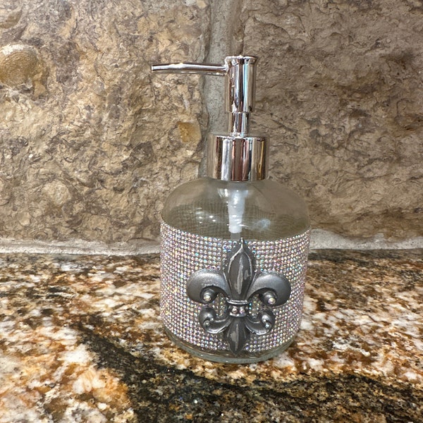 Glass embellished soap/lotion dispenser with chrome pump. AB crystal wrapped and adorned with a silver resin fleur de lis.