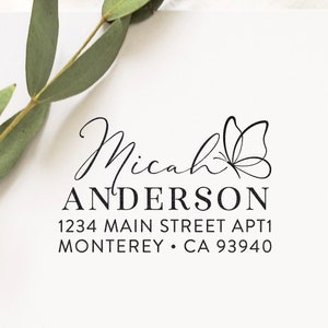May include: A black and white return address stamp with the name Micah Anderson, the address 1234 Main Street Apt 1 Monterey, CA 93940, and a butterfly design.