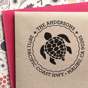 May include: A brown paper envelope with a black rubber stamp featuring a sea turtle and the text "THE ANDERSONS * 28711 PACIFIC COAST HWY * MALIBU, CA 90265 *"