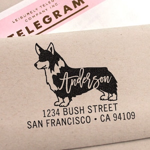 May include: A black and white silhouette of a corgi dog with the name "Anderson" written in cursive on its body. The address "1234 Bush Street, San Francisco, CA 94109" is printed below the dog.