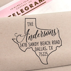 May include: A brown paper envelope with a black rubber stamp of the state of Texas. The stamp says "The Anderson's 1478 Sandy Beach Road Dallas, TX 75225".