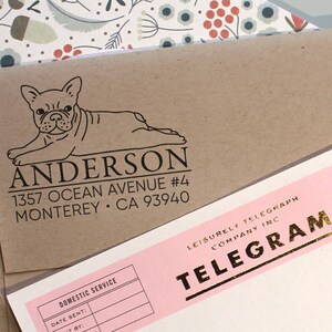 K&ouml;nnte beinhalten: Ein brauner Papierumschlag mit einer Schwarzwei&szlig;illustration eines franz&ouml;sischen Bulldoggen. Der Umschlag hat ein R&uuml;cksendeetikett mit dem Text "ANDERSON 1357 OCEAN AVENUE #4 MONTEREY &bull; CA 93940".