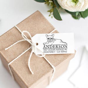 K&ouml;nnte beinhalten: Ein wei&szlig;es Geschenkanh&auml;nger mit einer Schwarzwei&szlig;illustration eines franz&ouml;sischen Bulldoggen. Der Anh&auml;nger tr&auml;gt den Text "Anderson 1357 Ocean Avenue #6 Monterey, CA 93940" aufgedruckt.
