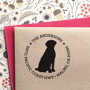 May include: A brown paper return address label with a black silhouette of a dog sitting. The text reads "The Andersons", "28711 Pacific Coast Hwy", "Malibu, CA 90265".