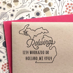 May include: A brown envelope with a black rubber stamp of the state of Michigan with the text "The Rolwings" and the address "1234 Waukazoo Dr Holland, MI 49424".