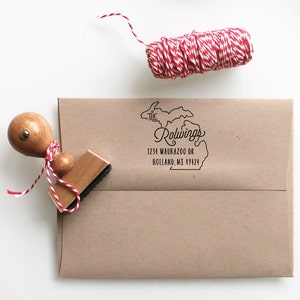 May include: A brown envelope with a black rubber stamp of the state of Michigan with the text "The Rowlings 1234 Waukazoo Dr Holland, MI 49424" printed on it.