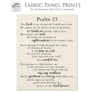 May include: A beige fabric panel print with Psalm 23 text in black cursive font. The text reads: "The Lord is my shepherd; I shall not want. He makes me lie down in green pastures. He leads me beside still waters. He restores my soul. He leads me in paths of righteousness for his name's sake. Even though I walk through the valley of shadow of death, I will fear no evil, for you are with me; your rod and your staff, they comfort me. You prepare a table before me in the presence of my enemies; you anoint my head with oil; my cup overflows. Surely goodness and mercy shall follow me all the days of my life, and I shall dwell in the house of the Lord forever."