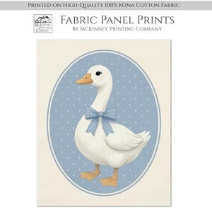 May include: A fabric panel print featuring a white goose with an orange beak and feet, wearing a blue and white gingham bow. The goose is centered within a blue oval frame with white polka dots, set against a cream-colored background.