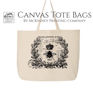 May include: A natural canvas tote bag with black and white vintage style graphic featuring a bee, crown, and floral wreath. The text on the bag reads "Margerie & Sorbonerie en Gros K. Maille a Tours 1885".
