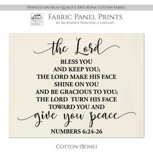 May include: A beige fabric panel print with black text that reads "the Lord bless you and keep you; the Lord make his face shine on you and be gracious to you; the Lord turn his face toward you and give you peace" and "Numbers 6:24-26".