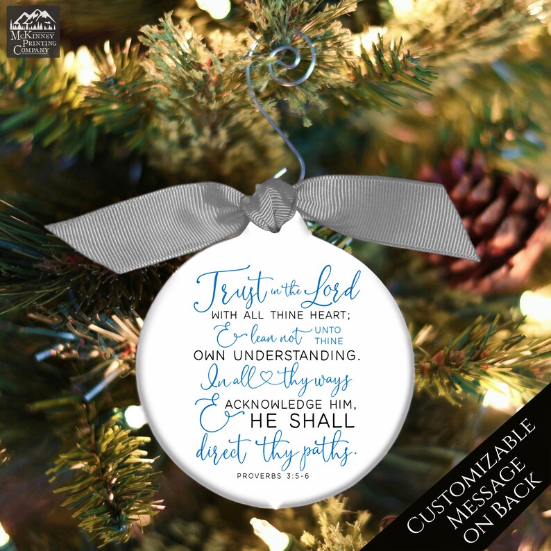May include: White Christmas ornament with a silver ribbon and hook, featuring the text "Trust in the Lord" and a Bible verse. The ornament is hanging on a Christmas tree. The back of the ornament is customizable.