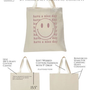 May include: A beige canvas tote bag with pink text that reads "have a nice day" and a pink smiley face. The bag is 15.5 inches tall and 14.5 inches wide. The bag is made of 12 oz 100% heavy cotton canvas with soft webbed cotton handles that have a 9 inch drop.