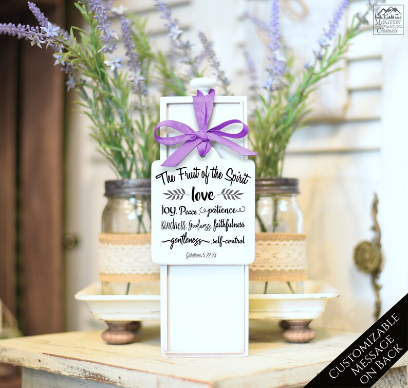May include: A white wooden box with a pull-out drawer, adorned with a purple ribbon. The front features the text "The Fruit of the Spirit" and related words. The box is displayed with lavender and mason jars.