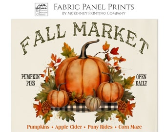 May include: Fall Market fabric panel print featuring a watercolor illustration of pumpkins, leaves, and a checkered tablecloth. The text "Fall Market" is in a vintage style font. The text "Pumpkin Pies" and "Open Daily" are also included. The text "Pumpkins, Apple Cider, Pony Rides, Corn Maze" is at the bottom of the print. The text "(Multiple Sizes Available) Cotton" is at the bottom of the print.