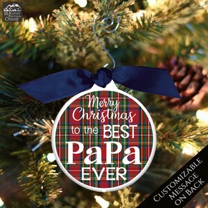 May include: Red and green plaid Christmas ornament with white text that reads "Merry Christmas to the Best Papa Ever".