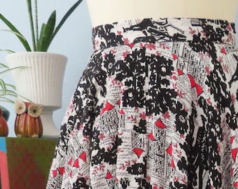 May include: A black and white skirt with a red floral print. The skirt is full and has a high waist.