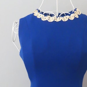May include: A royal blue sleeveless dress with a gold sequined neckline and hemline.