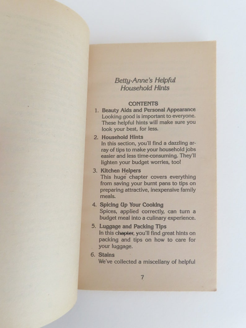 Peut inclure: Page ouverte d'un livre avec le titre "Betty-Anne's Helpful Household Hints" et une table des mati&egrave;res. Les sujets incluent les aides &agrave; la beaut&eacute;, les conseils m&eacute;nagers, les aides de cuisine, la cuisine, les bagages et les taches. Le num&eacute;ro de page est 7.