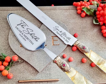 Gold Wedding Cake Cutting Set with Fabric Effect Handle Server and Knife, Antique Gold Washed Metal Ring with a Red Stone Decoration
